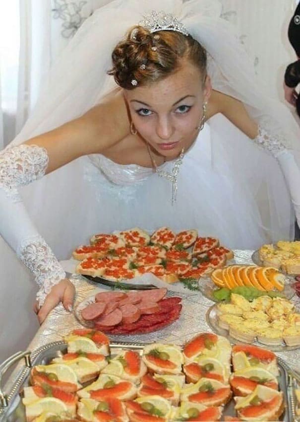 bride standing over a table of food 