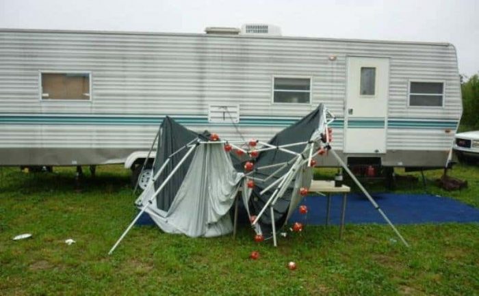 A collapsed tent in front of an RV 