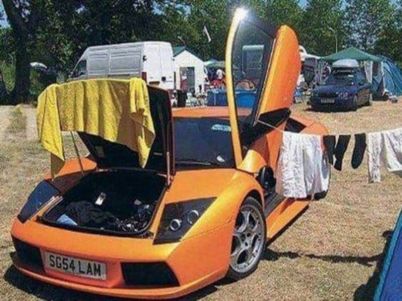 Clothes hanging to dry on an orange Lamborghini at a camping site