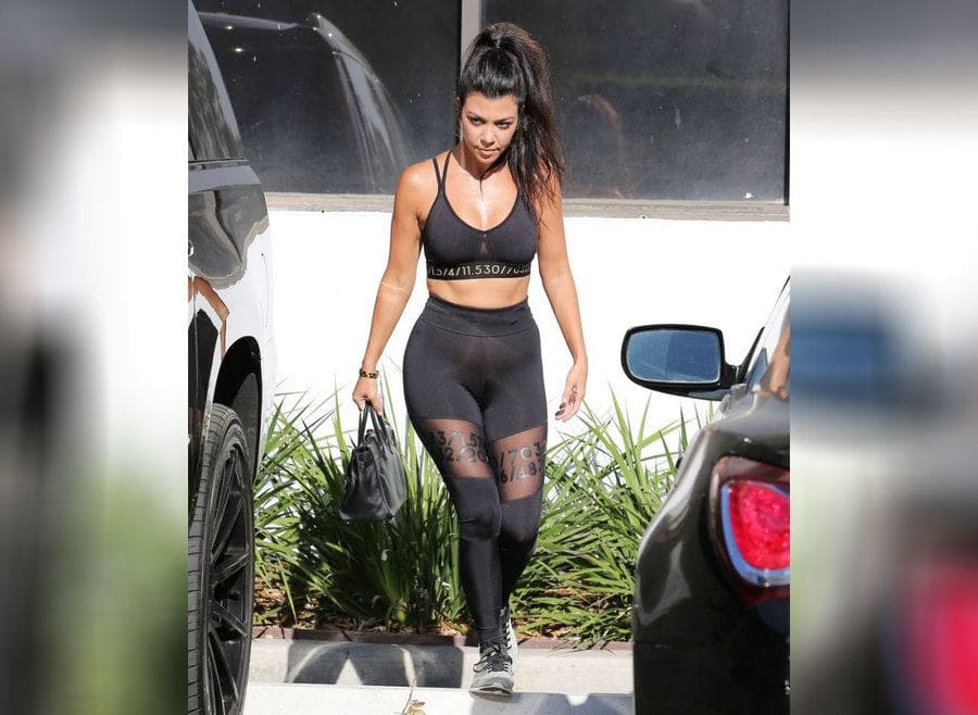 Kourtney Kardashian walking around in workout clothing. 