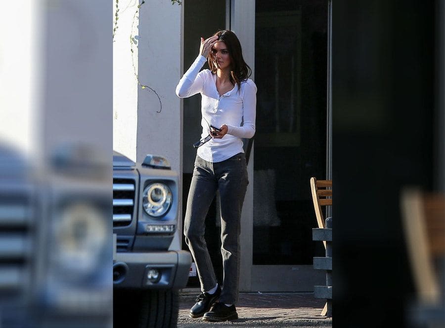 Kendall Jenner out and about in a white shirt and dark jeans. 