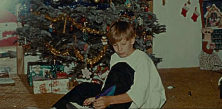 Nicholas Barclay as a boy sitting by the Christmas tree.