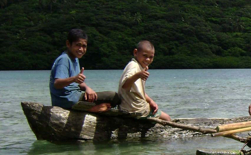 Boys sitting in a man-made boat 