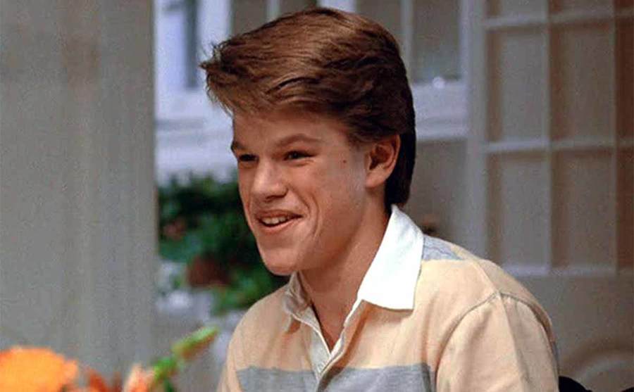 Matt Damon sitting at a breakfast table smiling in the film Mystic Pizza 