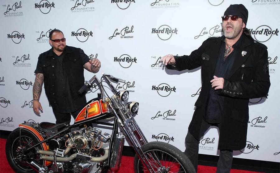 Shannon Aikau and Danny Koker posing with a motorcycle on the red carpet 