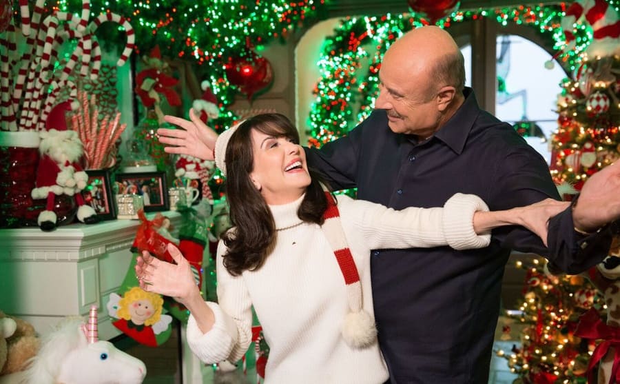 Robin and Dr. Phil joking around on a Christmas themed set 