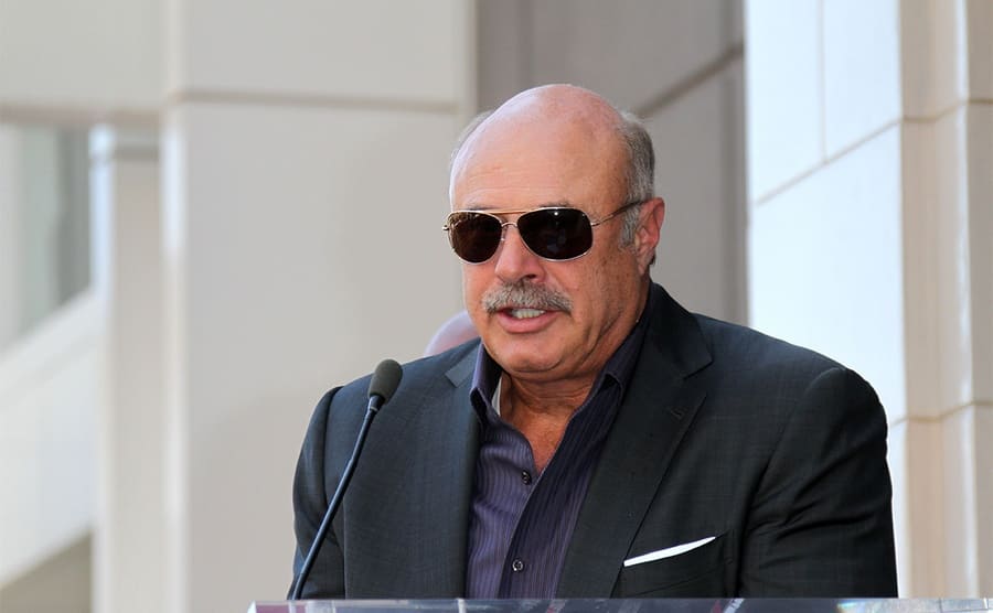 Dr. Phil behind a podium giving a speech in 2013