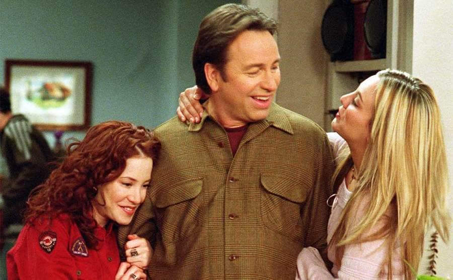 Amy Davidson, John Ritter, and Kaley Cuoco hugging in a scene from 8 Simple Rules… For Dating My Teenage Daughter