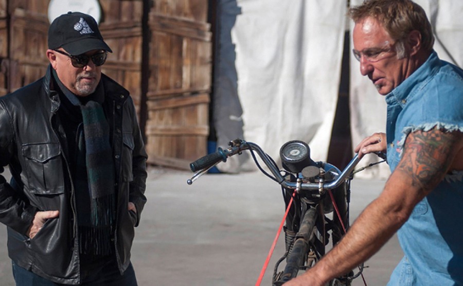 Rick helping Billy Joel with an old motorcycle 