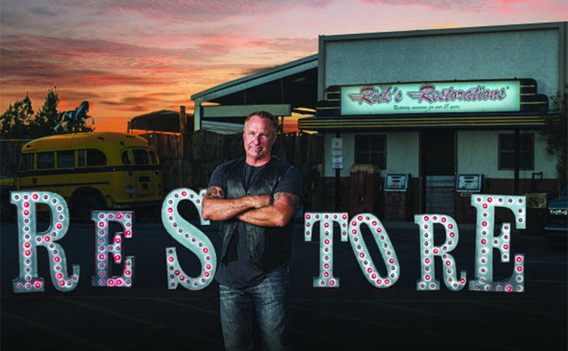 Rick standing in front of a sign that says Restore 