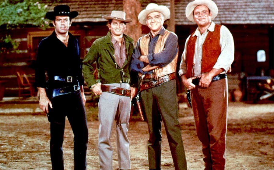 Pernell Roberts, Michael Landon, Lorne Greene, and Dan Blocker posing in their cowboy gear on the show Bonanza 