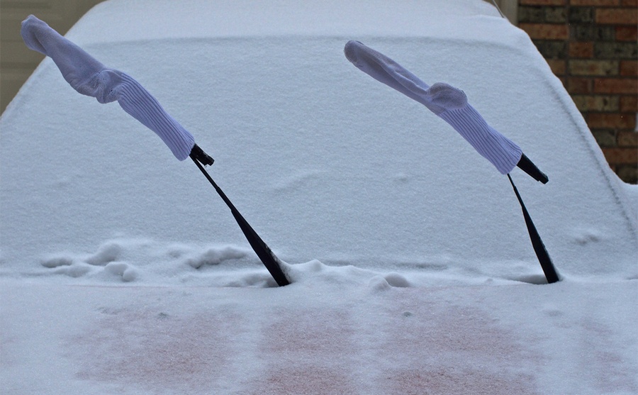 Socks on the windshield wipers of a snow-covered car 