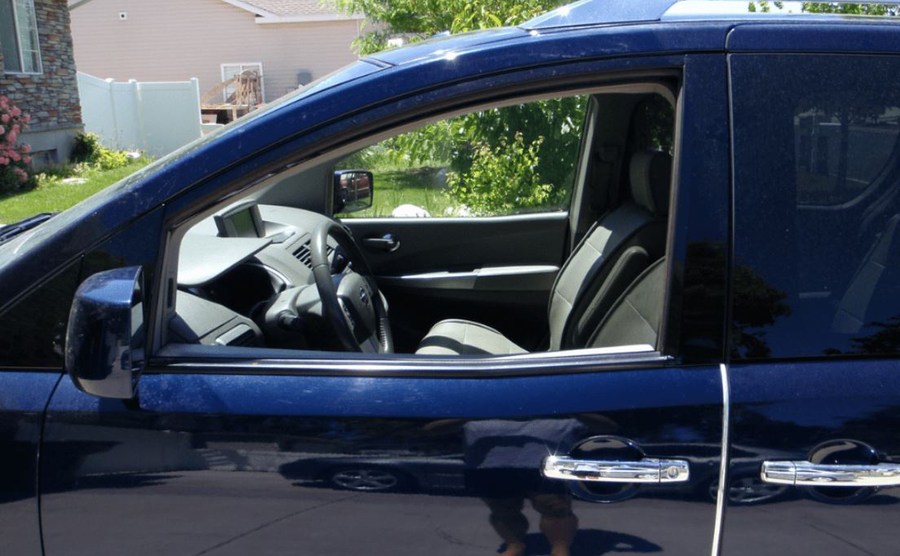 A navy blue minivan with the two front windows open 