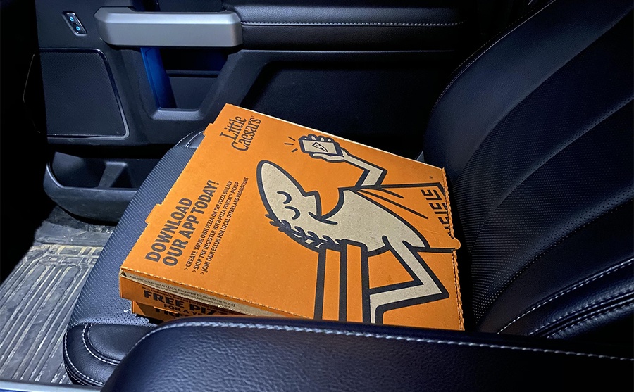 Pizza boxes staying warm on a passenger side heated seat 