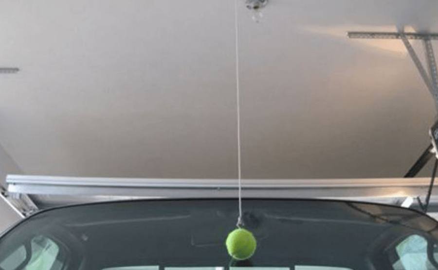 A tennis ball hanging down from a garage ceiling 