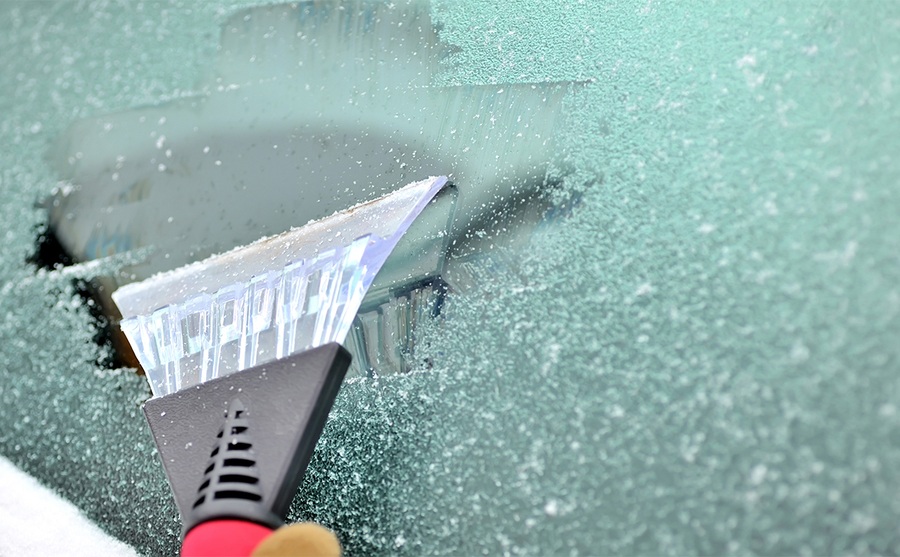 Scraping off the ice from a windshield 