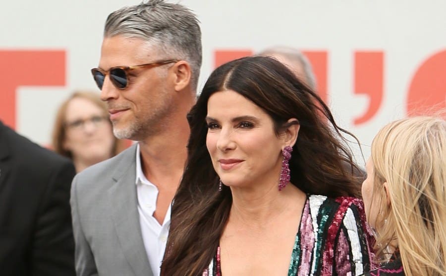 Sandra Bullock and Bryan Randall walking together on the red carpet 