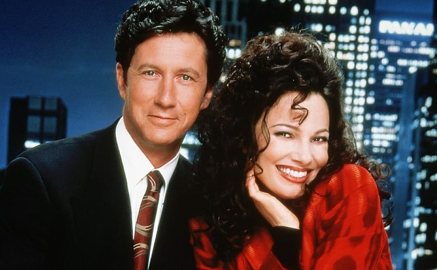Charles Shaughnessy and Fran Drescher posing together with a skyline backdrop 