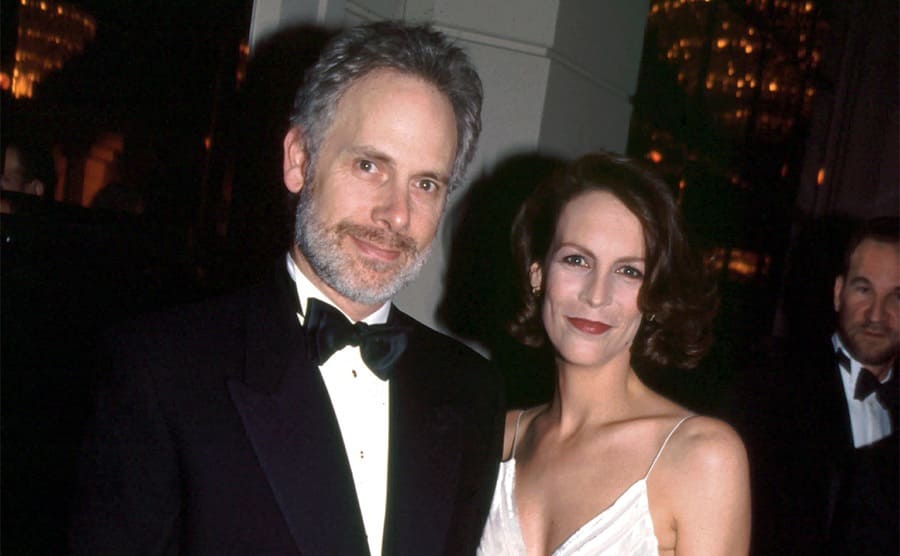 Christopher Guest and Jamie Lee Curtis posing on the red carpet at the Golden Globe Awards 1995