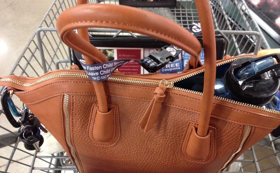 A purse buckled into a shopping cart 