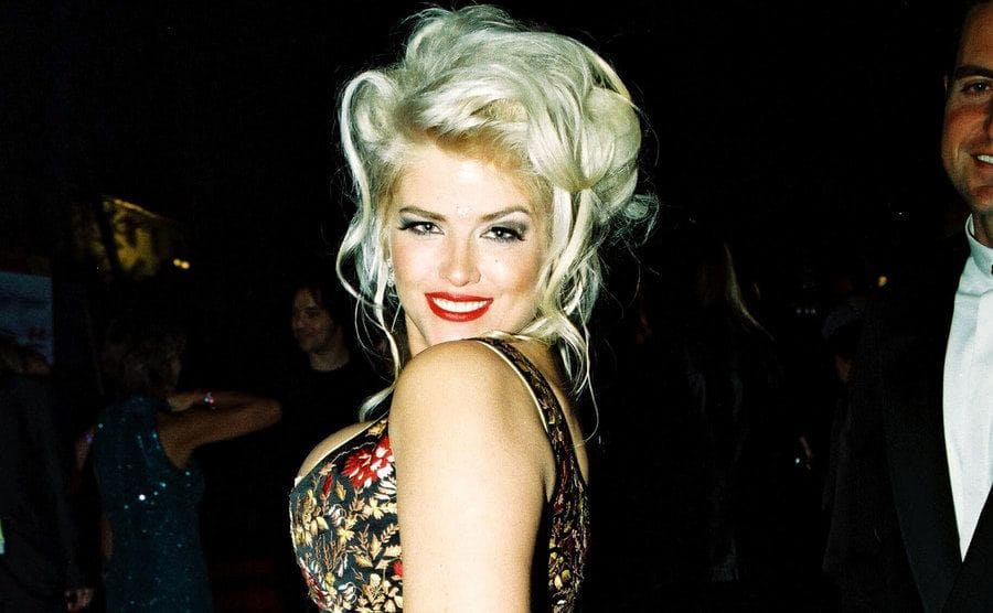 Anna Nicole Smith posing on the red carpet looking over her shoulder 