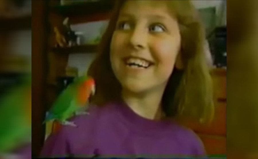 Beth Thomas as a teenager with a small parrot on her shoulder