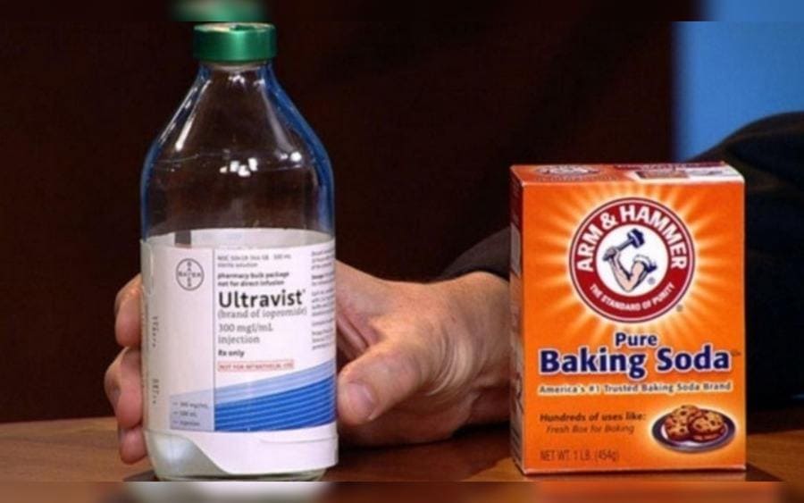  Un medicamento siendo sostenido al lado de una cajetita de bicarbonato de sodio