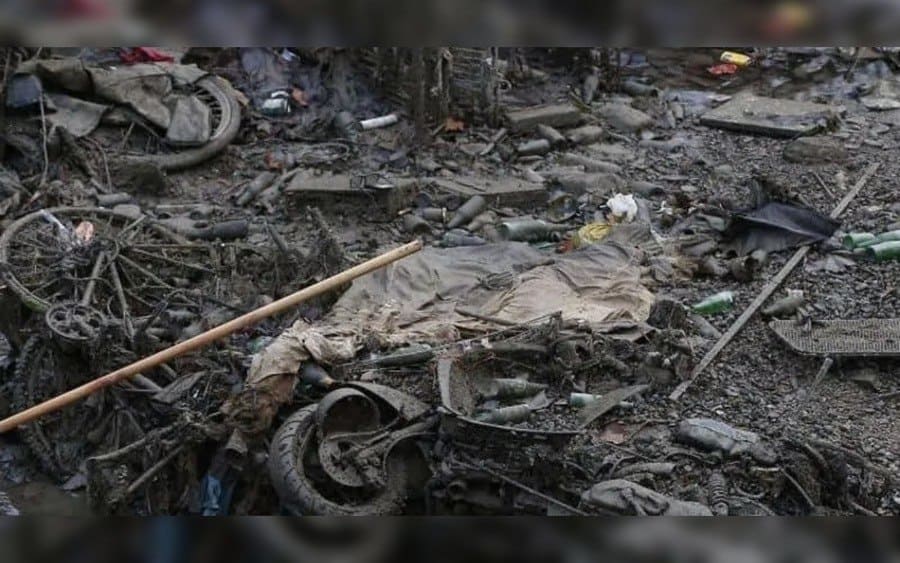 Escombros de bicicletas, botellas y desechos tirados.