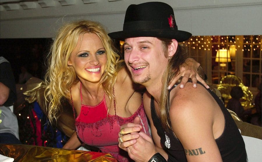 Pamela Anderson and Kid Rock sitting in a booth at a festival 