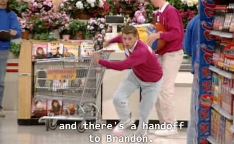 Kevin handing off a cart to Brandon while running around set to complete the task. 