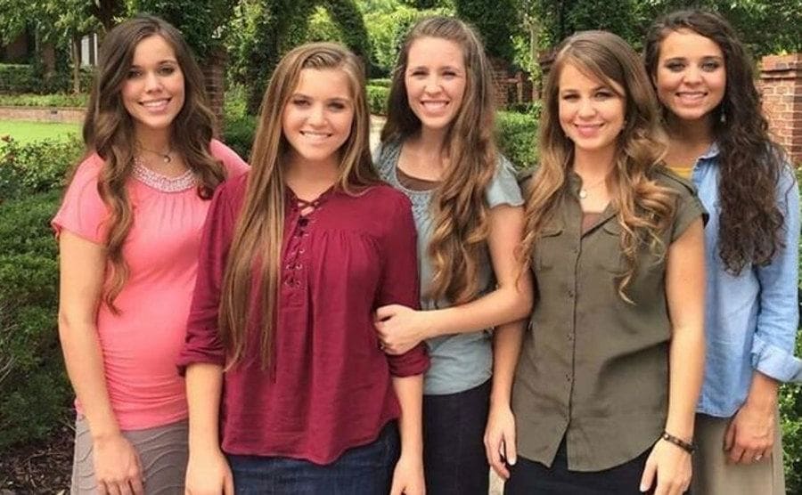 The Duggar Girls posing for a photo outside.