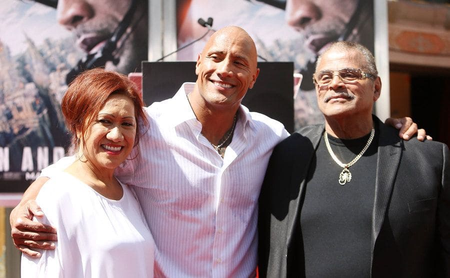 The rock with his parents on the red carpet 