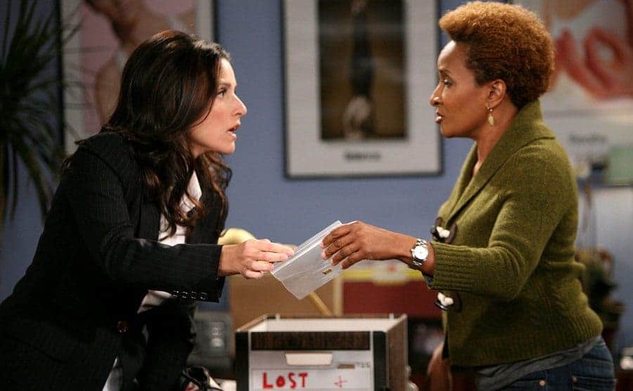 Julia Louis-Dreyfus with Wanda Sykes looking through a lost and found in a scene from The New Adventures of Old Christine 
