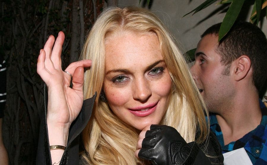 Lindsay Lohan standing outside of an event looking a bit drunk 