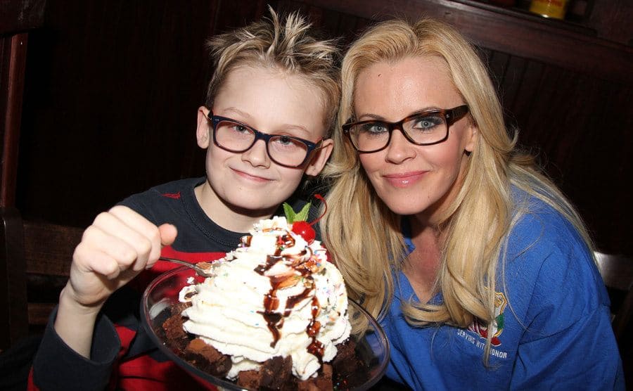 Evan Joseph Asher and Jenny McCarthy sitting together with a large ice cream Sunday in front of them with a cherry on top 