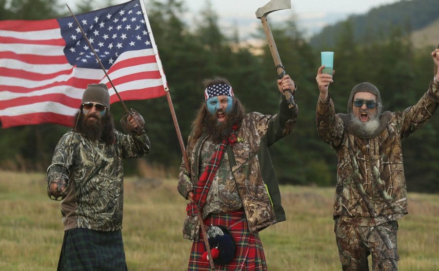 Members of Duck Dynasty waving an American flag. 