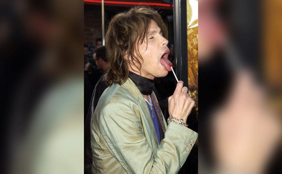 Steven Tyler licking a little lollypop with his enormous tongue. 