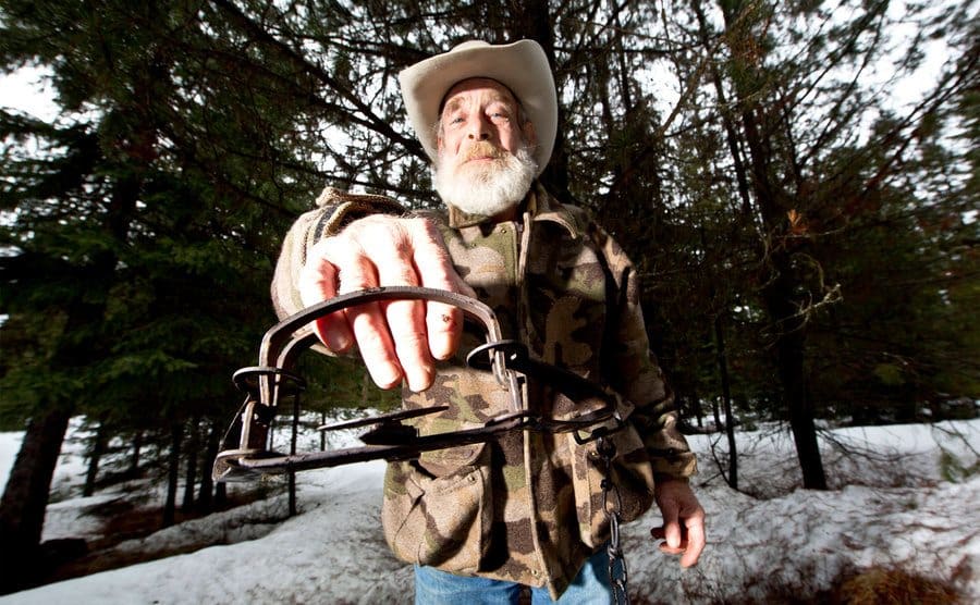 Tom Oar showing how dangerous life in the mountains can be by sticking his hand in a bear trap.
