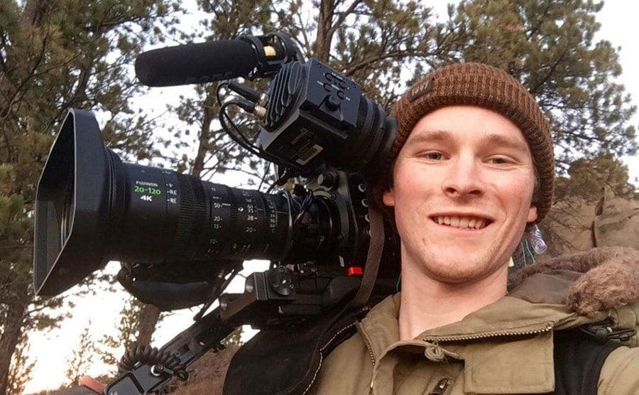 A young-looking cameraman taking a selfie while filming on location for Mountain Men.