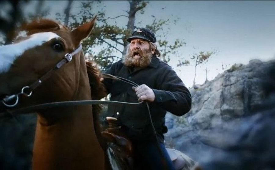 Rich Lewis riding a horse through the snow.