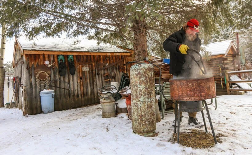 Lewis boiling things in a pot out in the snow.