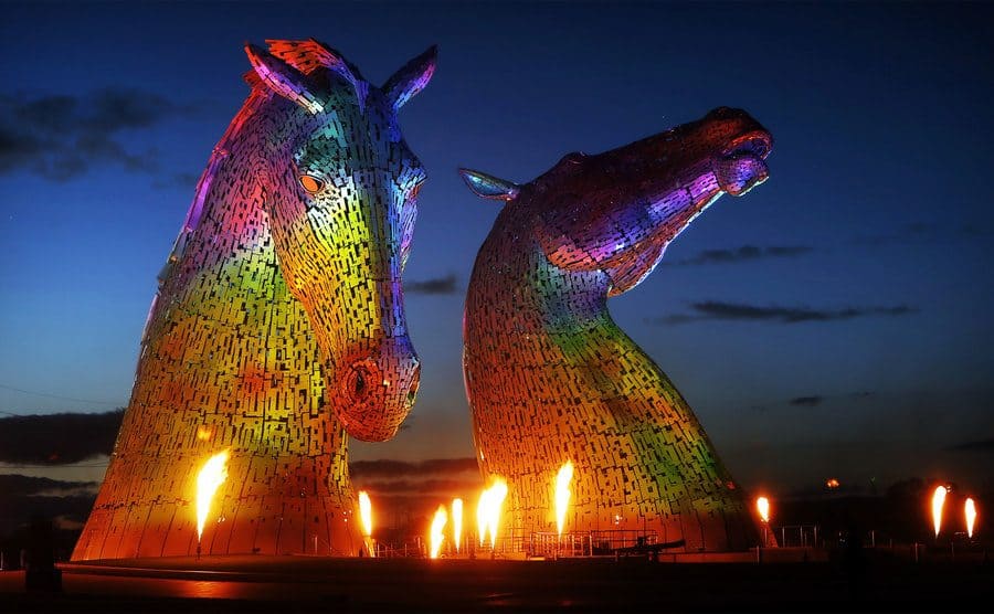 Esculturas de dos enormes cabezas de caballos iluminadas.