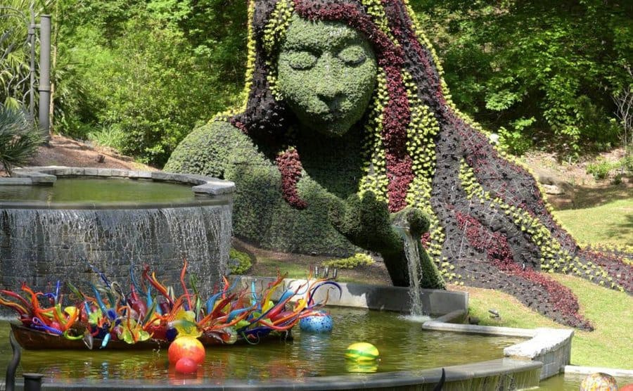 Escultura creada a base de flores y planta que evoca la madre naturaleza, en el parque bot+anico de Atlanta