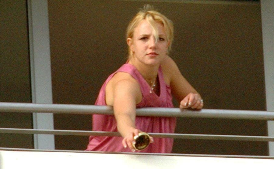 Britney vaciando un cenicero por el balcón de un hotel