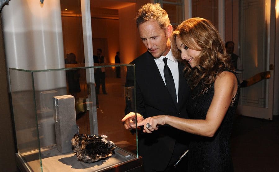 Todd and Giada looking at a display case while wearing fancy clothes 