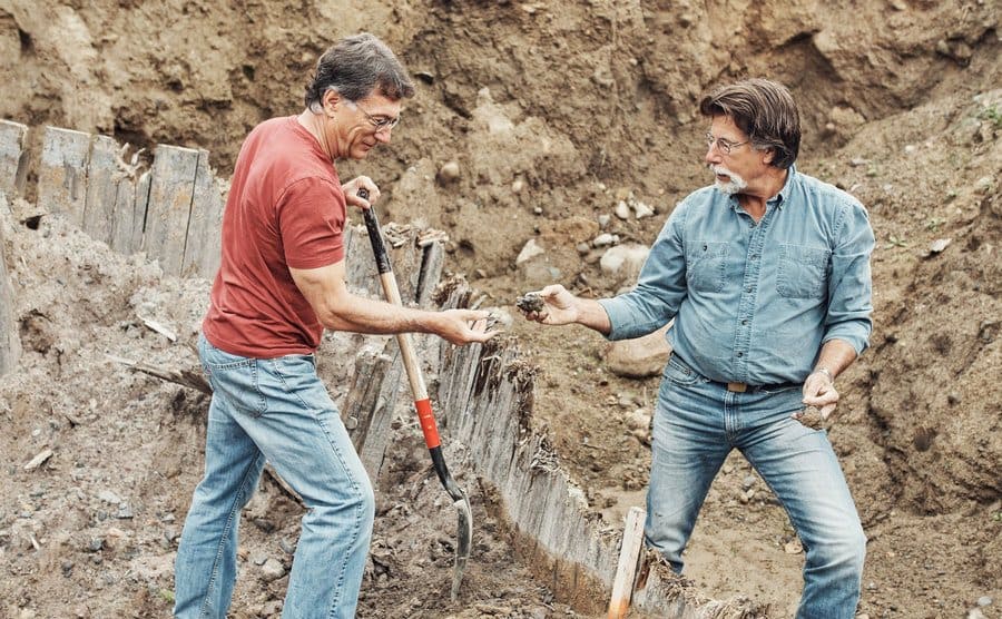 Rick and Marty are uncovering objects during a dig. 