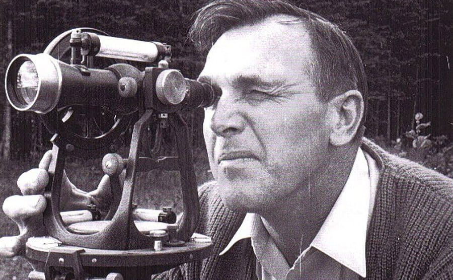 An old photo of Dan Blankenship looking through a telescope. 