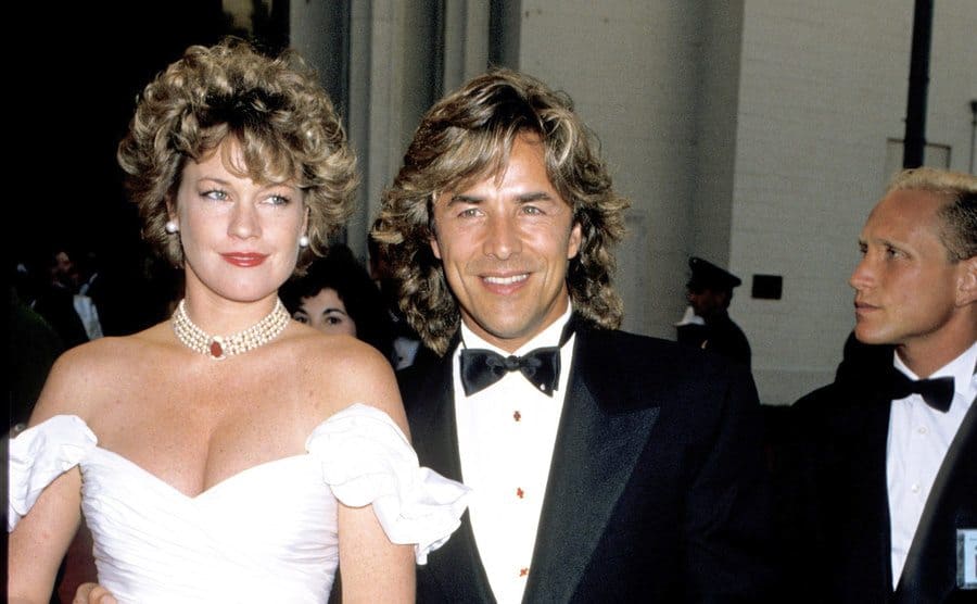 Don Johnson and Melanie Griffith posing arriving at the Academy Awards 
