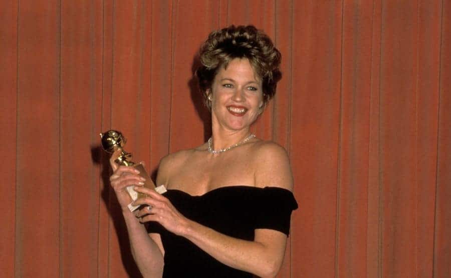 Melanie Griffith holding a Golden Globe Award
