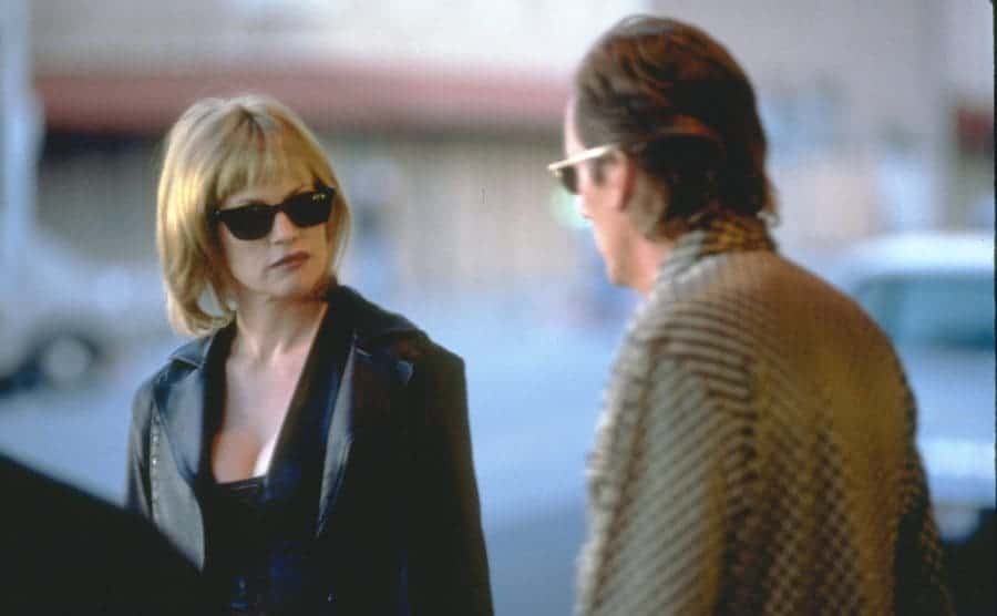 Melanie Griffith and James Woods looking serious outdoors while filming Another Day in Paradise 